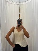 Musculosa gris de poliéster y rayón con spandex, escote en V y breteles anchos.