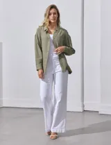 Camisa blanca de algodón con textura arrugada, cuello con solapa, abertura central con botones y bolsillo aplicado en el pecho. Mangas largas con largo regulable mediante presilla y botón.