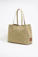 Bolso shopper grande Bimba y Lola modelo Chihuahua, color beige, fabricado en tejido gabardina de nylon con detalles de piel. Tiene tres compartimentos, cierre de mosquetón, logo metálico y bolsillo interior con cremallera.