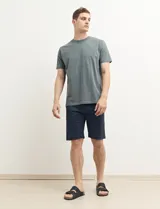 Bermuda de gabardina color verde con bolsillos laterales y traseros.