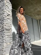 Vestido camisero largo con estampado de hojas en tonos marrones y blancos en la parte superior, y estampado de cebra en blanco y negro en la parte inferior.