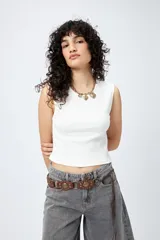 Musculosa blanca de punto acanalado con calce al cuerpo y terminación cropped.