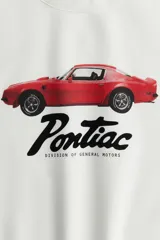 Buzo blanco de corte amplio con hombros caídos, cuello redondo y puños acanalados. Estampado frontal con un auto Pontiac rojo y el logo de la marca.
