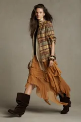 Camisa de mujer confeccionada en ramio 100% con estampado a cuadros en tonos beige, marrón y celeste. Tiene cuello solapa, manga larga con puños, bolsillo de plastrón en el delantero, bajo redondeado y cierre frontal con botones.