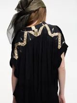 Blusa negra de manga corta con escote en V y bordados en la espalda.
