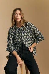 Camisa de manga larga con cuello mao y estampado paisley en tonos beige, marrón y azul sobre fondo claro. Presenta un calce holgado y puños ajustados.