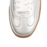 Zapatillas plateadas de cuero sintético con suela marrón, cordones blancos, talón azul y detalle de rayo blanco con borde rojo en el lateral.