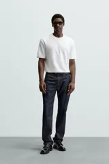Camiseta blanca de algodón interlock con elasticidad, corte recto, cuello redondo y mangas cortas.