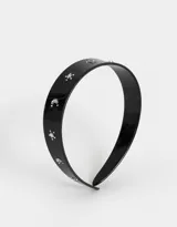Vincha rígida negra con apliques de glitter plateado en forma de lunas y estrellas.