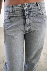 Pantalón de jean color rosa con efecto desgastado, corte recto y tiro medio.