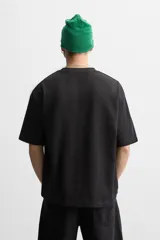Camiseta blanca de algodón compacto, corte relaxed fit, cuello redondo y mangas cortas.