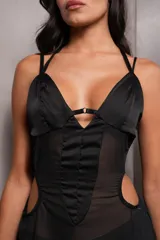 Vestido largo negro de seda con breteles finos, corte ajustado en el busto y falda con aberturas laterales. Presenta recortes en la cintura y espalda descubierta.
