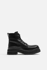 Bota de cuero negra con cordones, caña media y suela track.