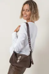 Cartera de cuero vacuno color marrón, con cierre metálico y correa regulable que permite uso al hombro o cruzada.