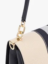 Cartera de lona color beige con rayas verticales azul marino y plateada. Tiene asa superior y correa extraíble y ajustable. El cierre es con solapa magnética y tiene el logo de Tommy Hilfiger en dorado.