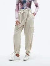 Pantalón color beige claro, de corte holgado, con bolsillos laterales y cinturón con hebilla metálica.