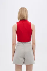 Top rojo de algodón con cuello alto, cierre frontal con cremallera y diseño sin mangas.