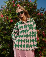 Camisa holgada con estampado de rombos azules y blancos, cuello solapa, manga corta y abotonada. Talle único, similar a un M.