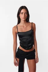 Corset negro con breteles finos regulables, escote recto y ballenas en el delantero.