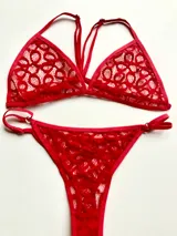 Conjunto de lencería de encaje negro, compuesto por un corpiño triangular con breteles ajustables y una bombacha less regulable.