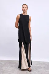 Blusa sin mangas color negro, de corte recto y largo irregular.