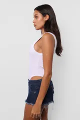 Body negro al cuerpo de microfibra pesada, con escote cuadrado y espalda baja. Terminaciones en collareta. Para facilitar acceso, broches snap en entrepierna y elástico interno en contorno de tiro para mejor ajuste de la prenda al cuerpo.