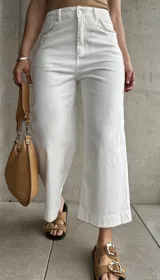 Pantalón capri blanco de tiro alto, corte recto y detalle de costuras onduladas en los bolsillos delanteros.