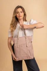 Cartera tipo tote bag color negro, con doble asa de mano y correa bandolera ajustable. Presenta un bolsillo rectangular en el frente.