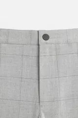Pantalón negro de corte slim fit, confeccionado en tejido elástico. Cuenta con cintura elástica, bolsillos frontales y traseros de vivo. Cierre frontal con cremallera y botón.