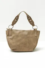 Cartera tipo hobo color beige con tachas plateadas en el borde inferior y asa de hombro trenzada.