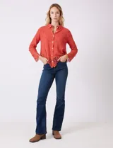 Camisa de algodón color naranja, con bordado suizo y encaje calado. Tiene cuello con solapa, botones frontales, mangas largas con terminación de encaje y ruedo asimétrico con galón de encaje.