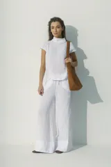 Blusa blanca de lino con cuello alto y mangas cortas con detalle de calado.