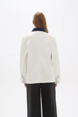 Chaqueta color crudo de algodón con cuello camisero y detalles en denim azul en cuello, bolsillo y puños.