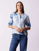 Blusa de lino estampada con flores azules, marca Hester & Orchard. Cuello a la base y abertura central con botones.