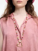 Camisa gris sin mangas confeccionada en viscosa teñida en frío, con efecto gastado. Tiene cuello clásico, cartera oculta y ruedo irregular más largo en los laterales.