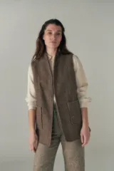 Chaleco color beige, entallado, con solapa, bolsillos plaqué y terminaciones envivadas.