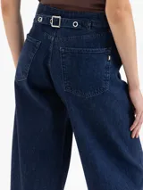 Jeans de denim azul oscuro, tiro alto, con calce slouchy y pierna ancha y corta. Presenta costuras curvas distintivas en el frente que definen la forma de la pierna.