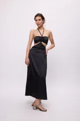 Vestido midi amarillo de satén con escote halter, trenzas en cuello y cintura, cut-outs laterales y falda recta.