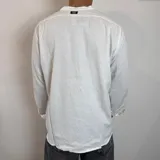 Camisa de lino blanca con cuello mao, manga larga y corte regular.