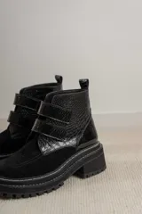 Botas cortas de cuero color hueso, con puntera redondeada, ajuste con doble tira con velcro color verde oliva y suela track color negro.