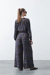 Pantalón de fit wide leg con estampado abstracto en tonos azul, marrón y beige. Presenta cintura elástica y caída fluida.