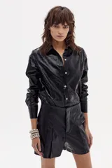 Short de lino negro metalizado con cintura alta, tablas delanteras, bolsillos laterales y cierre frontal con gancho metálico.