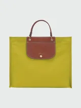 Bolso tipo shopper Longchamp modelo Le Pliage Cabas L, color verde esmeralda con solapa y asas cortas de cuero marrón.