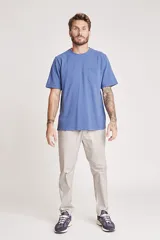 Pantalón de vestir color beige, de corte recto, con bolsillos laterales y traseros. Se ajusta a la cintura con cinturón de cuero marrón.