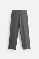 Pantalón gris de corte ancho con cintura elástica, pliegues frontales, bolsillos laterales y traseros de vivo. Incluye detalle de hebilla metálica en la trabilla y cierre frontal con cremallera y botón.