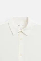 Camisa celeste de corte recto, manga corta y cuello solapa.
