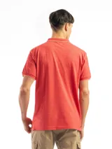 Remera polo verde con cuello y mangas con borde blanco, confeccionada en algodón.