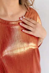 Remerón dorado con textura brillante y mangas cortas.