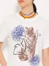 Remera blanca de algodón pima con estampado de un tigre y flores.