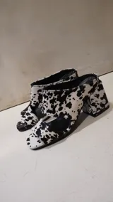 Mules con estampado animal en blanco y negro, con puntera cuadrada y tacón geométrico.